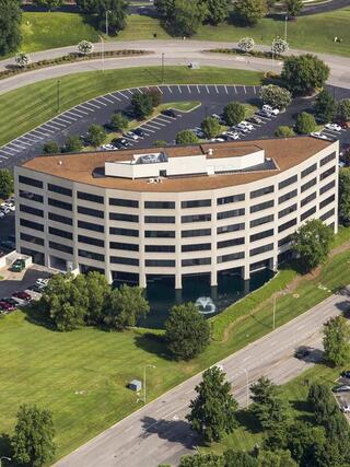 Aerial view of Lakeview Place Office, a modern multi-story commercial office building surrounded by landscaped grounds, parking, and water features.