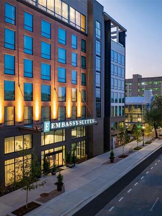 Exterior view of Embassy Suites by Hilton Chattanooga Downtown featuring modern architecture, illuminated hotel signage, and a contemporary streetscape in downtown Chattanooga.