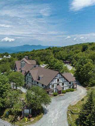 Aerial view of 4 Seasons at Beech Mountain featuring alpine-style mountain lodging surrounded by lush forest landscapes and scenic Blue Ridge Mountain views.