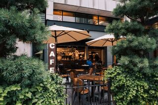 Cafe at Bobby Hotel Nashville – cozy outdoor coffee shop and café with patio seating, umbrellas, greenery, and downtown Nashville vibes.